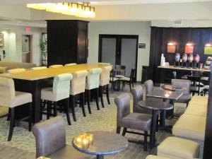 a restaurant with a bar and tables and chairs at Hampton Inn Lindale/Tyler in Lindale