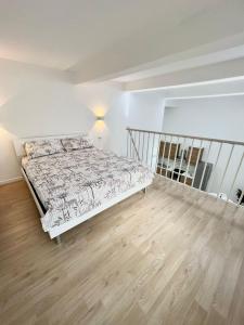 een witte slaapkamer met een bed en een houten vloer bij Cozy Apartment Milano Dergano M3 in Milaan