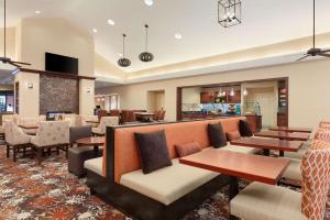 a lobby of a hotel with tables and chairs at Homewood Suites Medford in Medford
