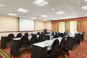Homewood Suites Medford في ميدفورد: قاعة اجتماعات مع طاولات وكراسي وطاولة بيضاء