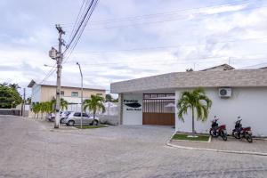 due moto parcheggiate di fronte a un edificio di Paraiso Barra Hotel a Barra de Santo Antônio