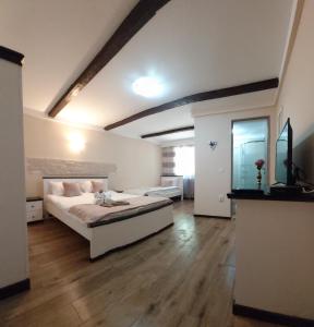 Un dormitorio con una cama grande en una habitación. en Casa de oaspeti Abby cu piscina si jacuzzi, en Moldoveneşti