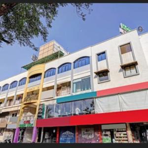 ein großes weißes Gebäude mit Fenstern auf einer Straße in der Unterkunft Hotel Long Stay in Ahmedabad