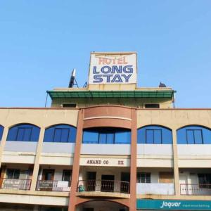 a large building with a sign on top of it at Hotel Long Stay in Ahmedabad