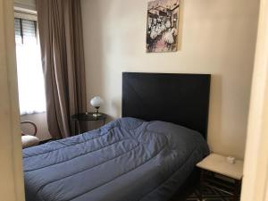 um quarto com uma cama com um edredão azul em The Wall Montevideo [ 105 ] Live in the Old Town em Montevidéu