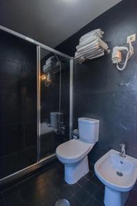 a bathroom with a toilet and a shower and a sink at Casa do Pinto in Arouca