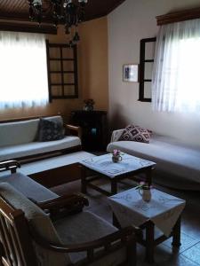 a living room with a couch and two tables at Gold Coast cottage house, ideal for families in Sozopoli