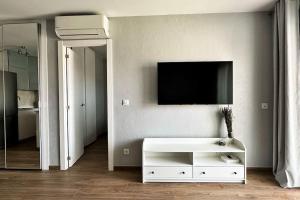 uma sala de estar com uma televisão e um armário branco em Apartamento acogedor , Blanes em Blanes