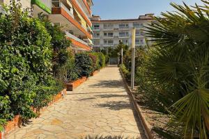 a stone walkway in front of a building with plants at Apartamento acogedor , Blanes in Blanes