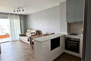 eine Küche und ein Wohnzimmer mit einem Sofa und einem Tisch in der Unterkunft Apartamento acogedor , Blanes in Blanes