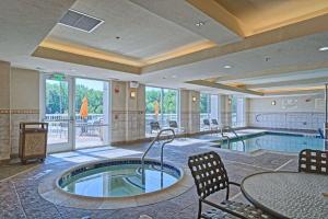 Habitación de hotel con piscina, mesa y sillas en Hilton Garden Inn by Hilton Mount Laurel en Mount Laurel