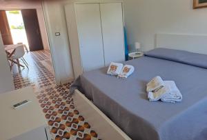 a bedroom with a bed with towels on it at Villa Rita Apartment in Fontane Bianche