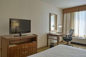 Habitación de hotel con cama y escritorio con TV. en Hilton Garden Inn by Hilton Mount Laurel en Mount Laurel