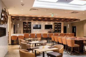 a restaurant with tables and chairs and a bar at DoubleTree by Hilton Kitchener in Kitchener