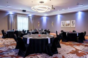 uma sala de conferências com mesas e cadeiras e um lustre em DoubleTree by Hilton Kitchener em Kitchener