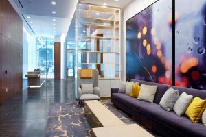 a living room with a couch and a painting at Hilton Club The Central at 5th New York in New York