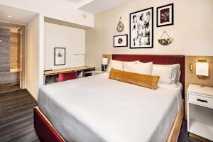 a hotel room with a bed and a desk at Hilton Club The Central at 5th New York in New York +14 photos