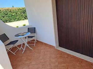 a balcony with a table and chairs and a door at Villa Rita Apartment in Fontane Bianche
