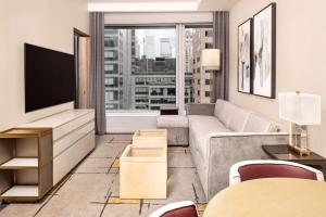 a living room with a couch and a tv at Hilton Club The Central at 5th New York in New York