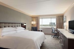 a hotel room with a large bed and a television at Hilton Philadelphia City Avenue in Philadelphia