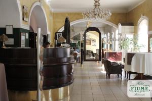 a restaurant with a table and a chandelier in a building at Fiume Hotel in Békéscsaba