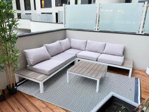 um sofá e uma mesa de centro numa varanda em Appartement 4P U Arena em Nanterre