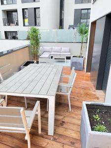 uma mesa de madeira e cadeiras num pátio em Appartement 4P U Arena em Nanterre