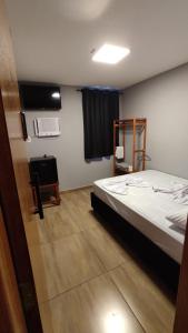 a bedroom with a bed and a television in it at Hotel Platina in Juiz de Fora