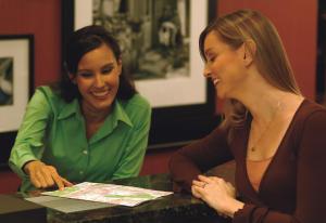 Dos mujeres sentadas en una mesa mirando un periódico en Hampton Inn & Suites Nashville at Opryland, en Nashville