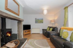 a living room with a couch and a fireplace at Weasels Nest in Bodmin