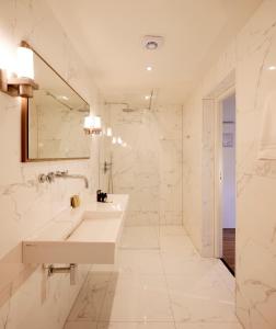 ein weißes Badezimmer mit einem Waschbecken und einem Spiegel in der Unterkunft Valuas in Venlo