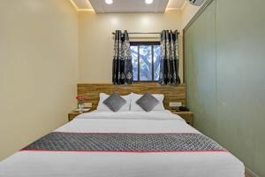 a bedroom with a large bed and a window at Hotel Kiwi International Near Chhatrapati Shivaji International Airport in Mumbai
