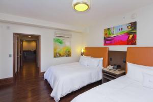 a hotel room with two beds and a painting on the wall at The Tudor Arms Hotel Cleveland - a DoubleTree by Hilton in Cleveland +31 photos