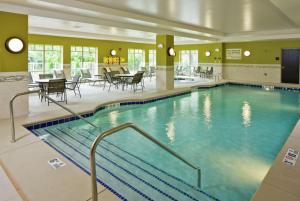 een groot zwembad in een hotel met tafels en stoelen bij Hampton Inn & Suites Saginaw in Saginaw