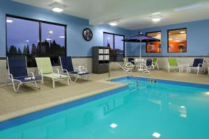 una gran piscina con sillas y sombrilla en Hampton Inn Hagerstown-Maugansville, en Hagerstown