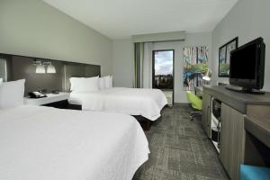 a hotel room with two beds and a flat screen tv at Hampton Inn Hagerstown-Maugansville in Hagerstown