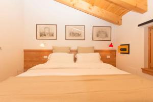 a bedroom with a large bed with white sheets at Lovely apt in Pinzolo Val Rendena 7 in Pinzolo