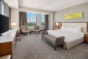 a hotel room with a bed and a flat screen tv at Hilton Rochester Mayo Clinic Area in Rochester