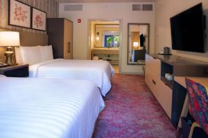 a hotel room with two beds and a flat screen tv at Cliffrose Springdale, Curio Collection By Hilton in Springdale