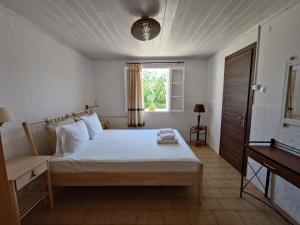 Un dormitorio con una cama grande y una ventana en Elena Apartments, en Vathí - Ítaca