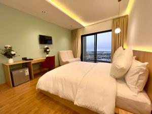 - une chambre avec un lit, un bureau et une fenêtre dans l'établissement Les Roches De Mazagan, à El Jadida