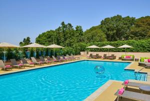 a pool with chairs and umbrellas at a hotel at Hilton Los Angeles North-Glendale & Executive Meeting Center in Glendale