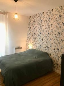 - une chambre avec un lit vert et du papier peint floral dans l'établissement Maison hypercentre et bord de mer, à Villers-sur-Mer