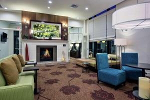 a living room with a fireplace and a table and chairs at Hilton Garden Inn Lincoln Downtown/Haymarket in Lincoln