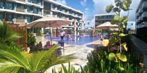a pool with a water park with people playing in it at Mana Beach Muro Alto Resort in Porto De Galinhas
