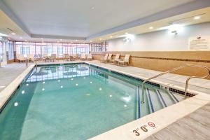 una gran piscina en un hospital con sillas y mesas en Homewood Suites by Hilton Bridgewater/Branchburg, en Branchburg Park