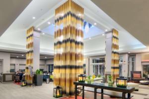 a lobby with a large column in a building at Hilton Garden Inn Livermore in Livermore