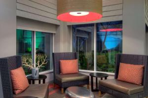 een patio met stoelen en tafels en een groot raam bij Hilton Garden Inn Livermore in Livermore