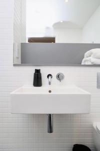 Baño blanco con lavabo y espejo en Unique comfortable Apartment, en Abbey Wood