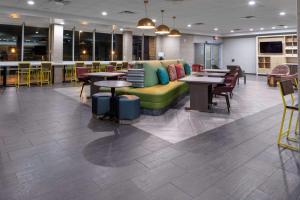 un ristorante con divano verde, tavoli e sedie di Home2 Suites By Hilton Page Lake Powell a Page